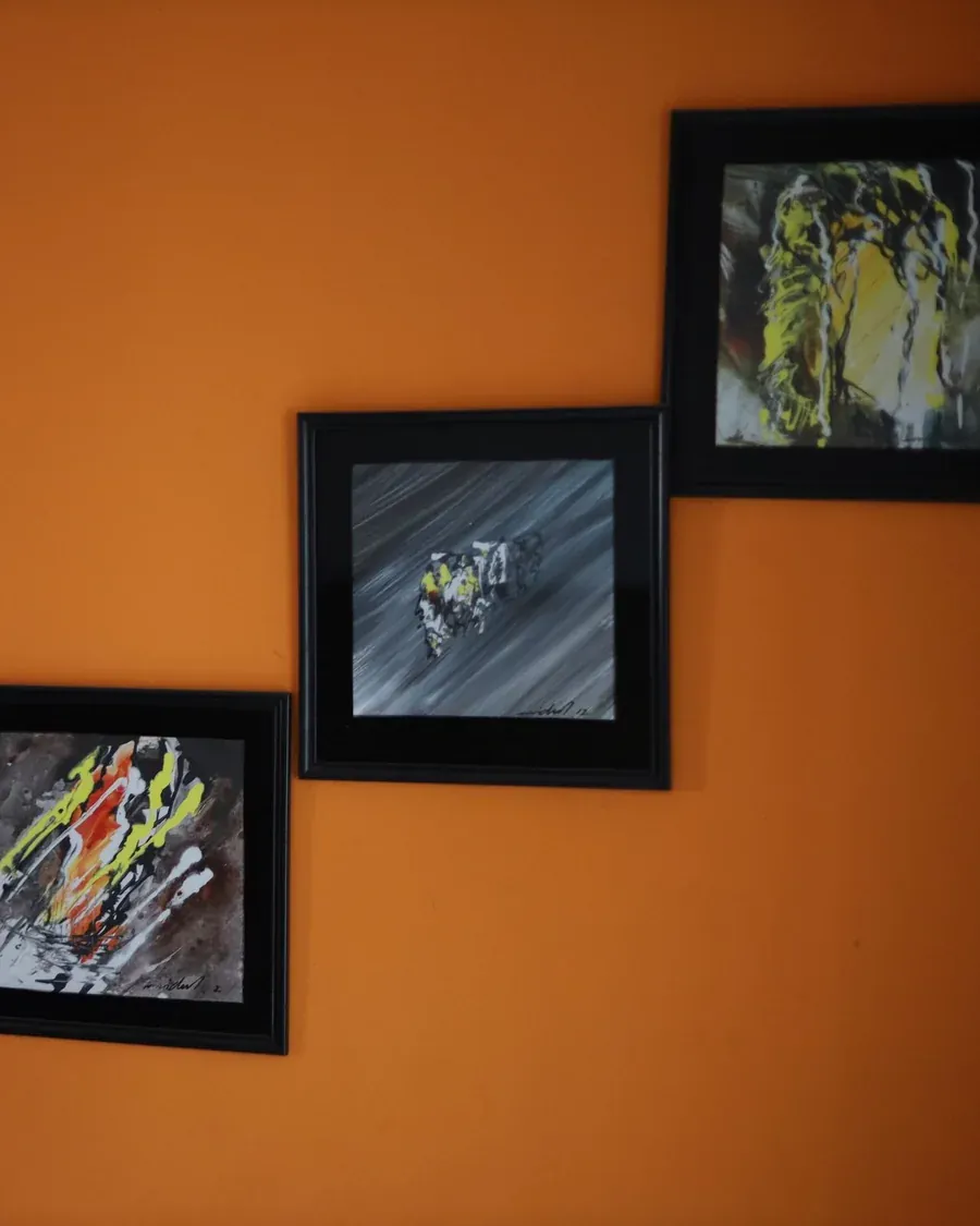 Framed artwork on an orange office wall