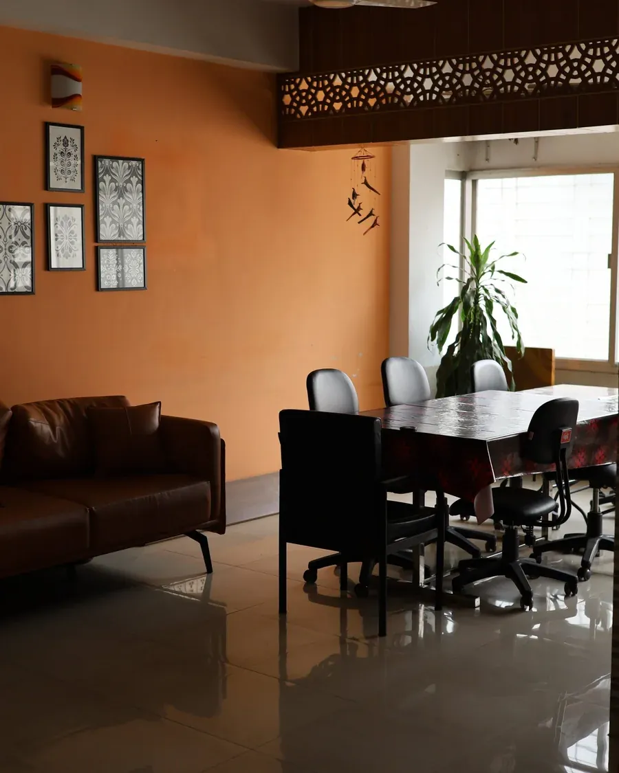 Meeting area with a leather sofa and conference table by a window